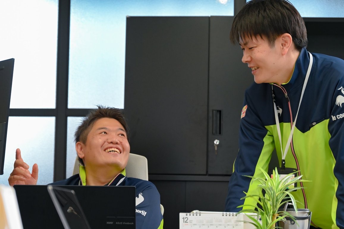 デスクを囲んで言葉を交わす職員