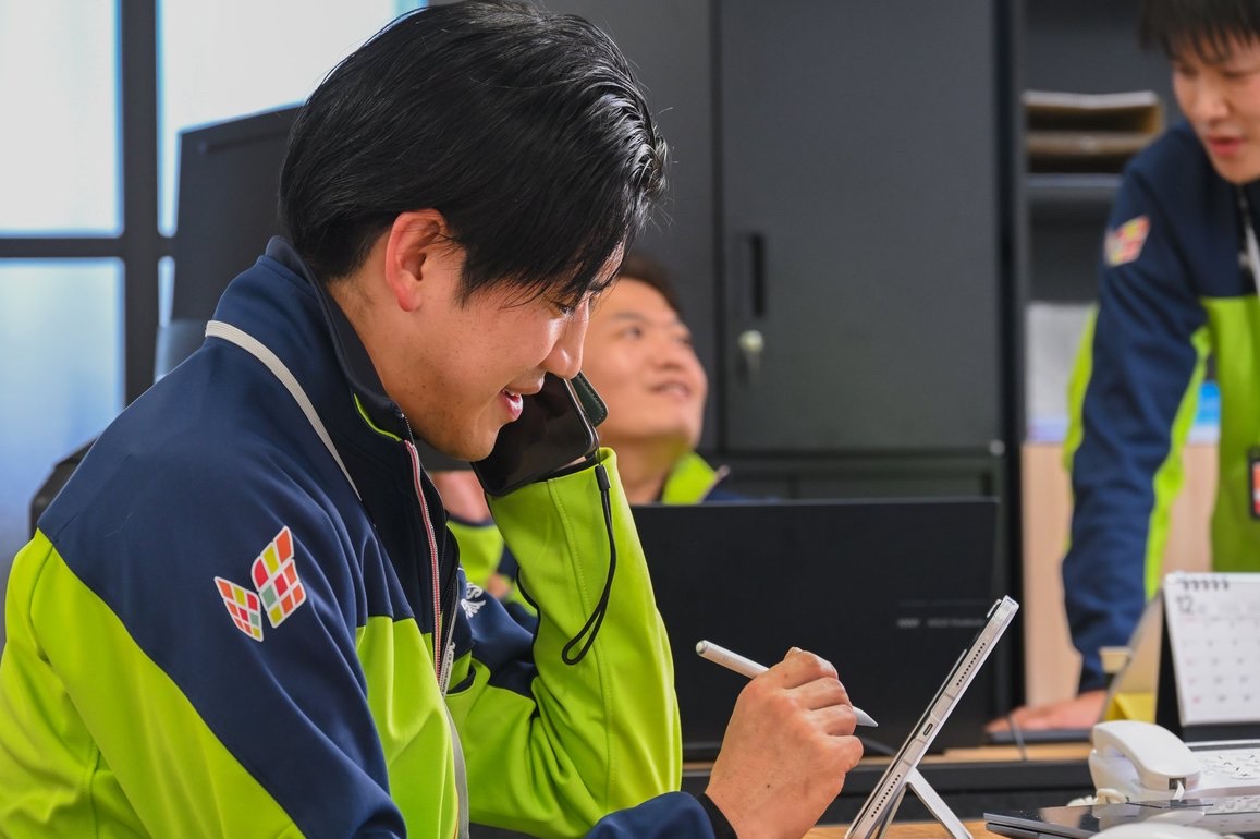 仲間と会話しながら業務を進める様子